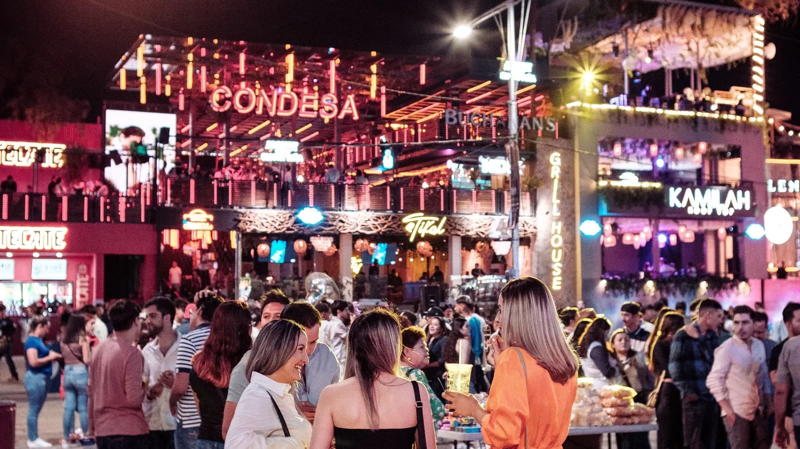 Foule devant les bars illuminés au néon dans le centre d'Ayia Napa, le soir