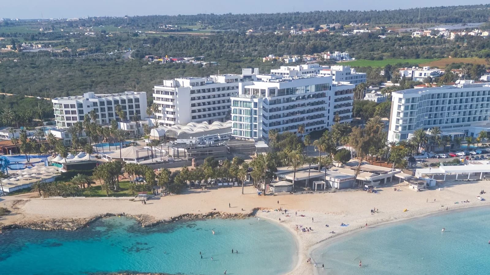 Hôtels blancs derrière Nissi Beach à Ayia Napa, entre deux criques d'eau turquoise