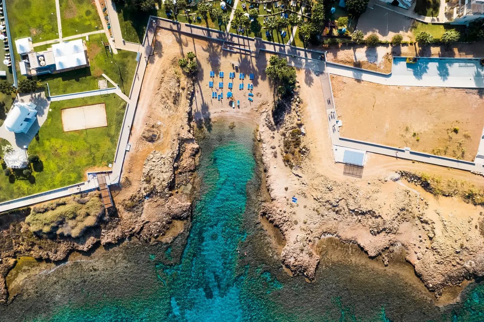 Vue aérienne d'une crique de Protaras, à Chypre, avec une eau turquoise et quelques transats bleus