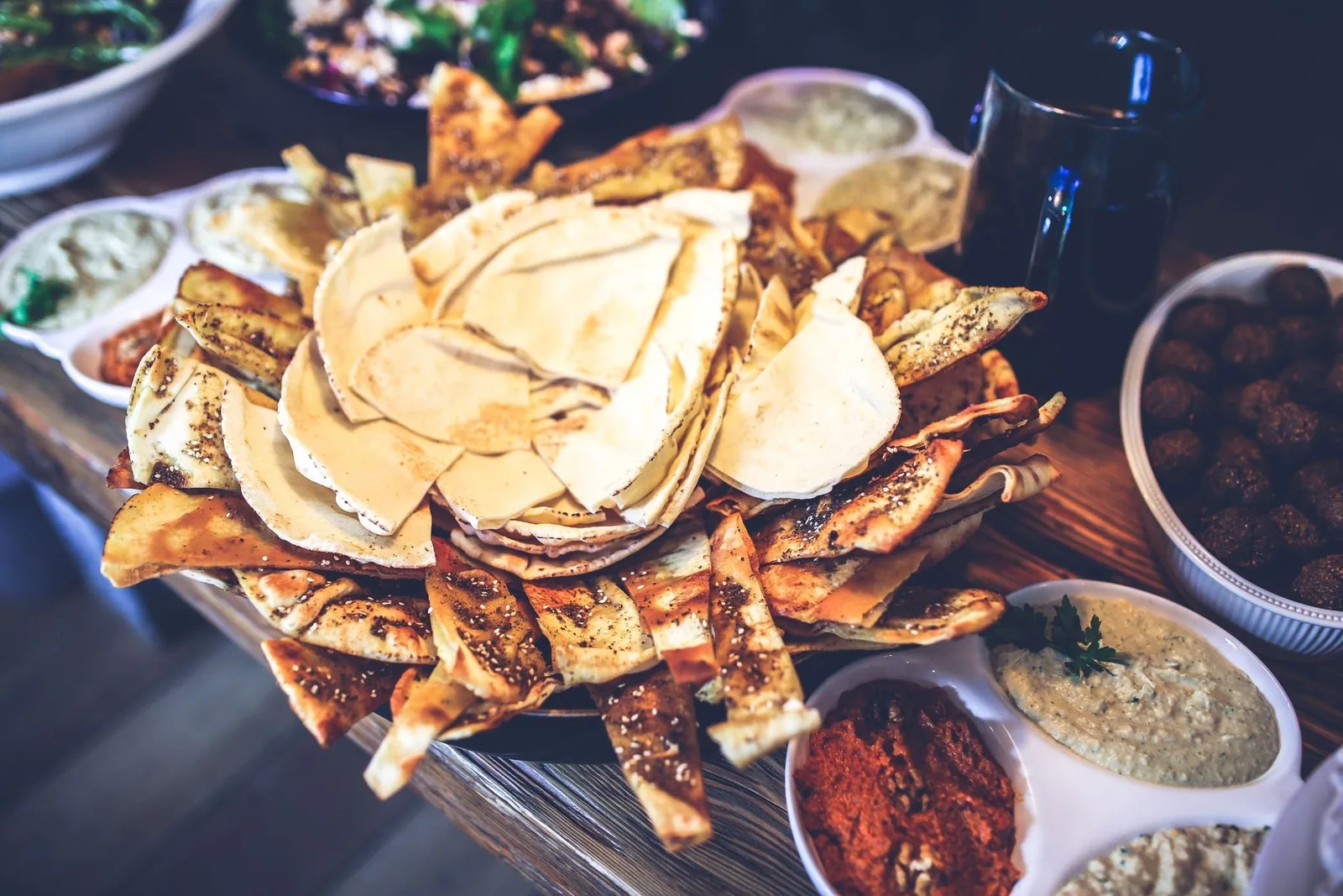 Table de meze avec pita grillée, falafels et dips en petites assiettes