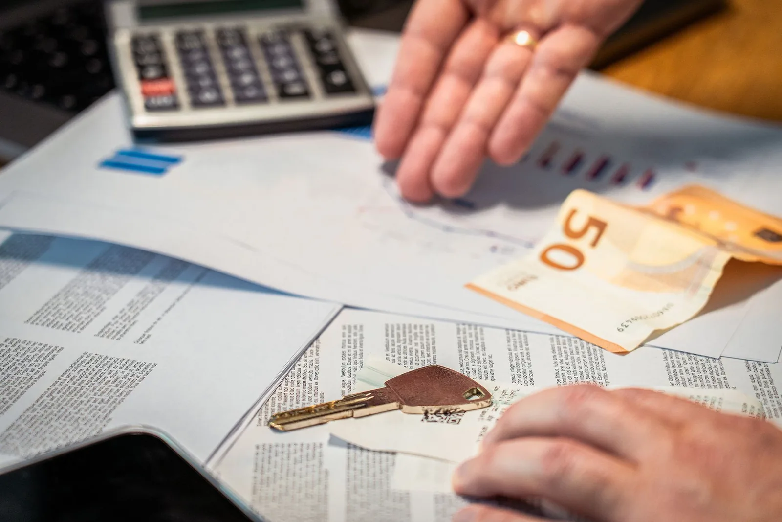 Calculatrice, billets en euros et documents fiscaux sur un bureau