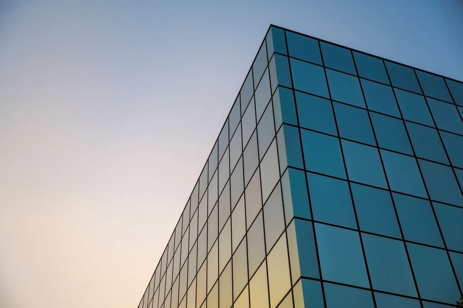 Immeuble de bureaux moderne en verre au coucher du soleil, fiscalité des sociétés