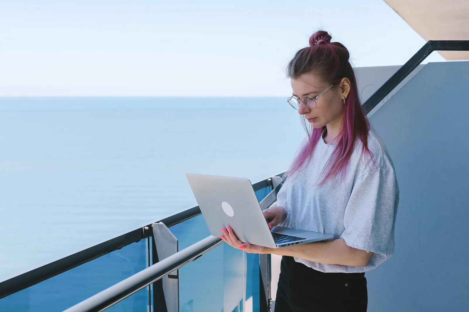 Personne travaillant sur un ordinateur portable sur un balcon face à la mer, à Chypre