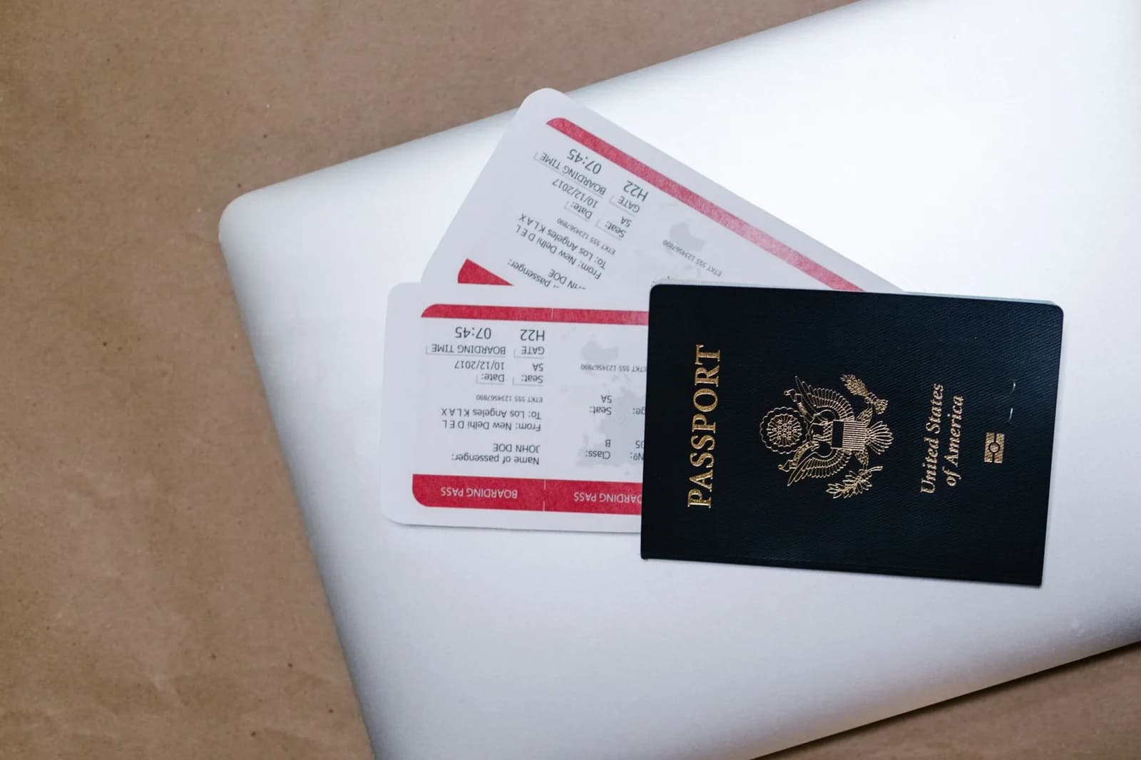 Passeport et cartes d'embarquement posés sur un ordinateur portable, visa nomade numérique