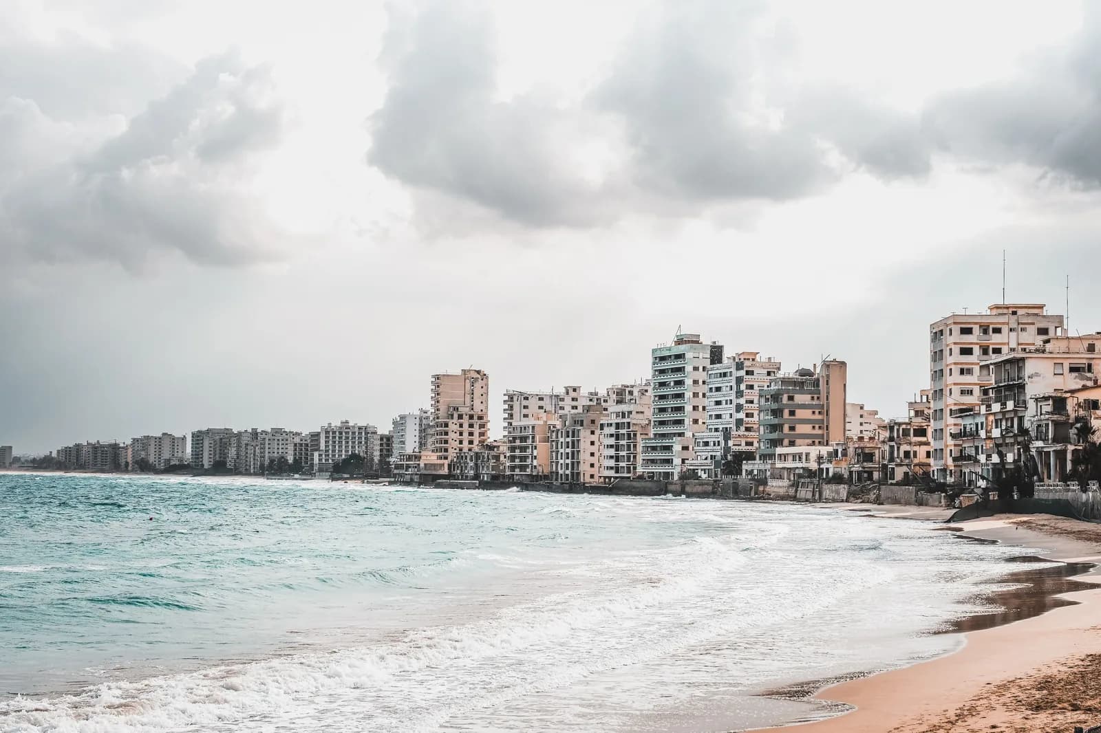 Plage de sable de Varosha à Famagouste, avec la ligne d'hôtels et d'immeubles abandonnés à l'horizon